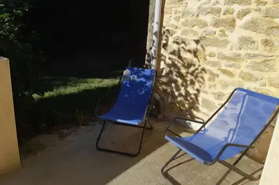 two blue chairs sitting next to a brick wall at Studio dans un cadre champêtre in Mas-Saintes-Puelles
