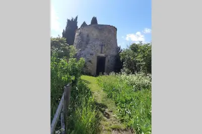 an old building with a door in the middle of a field at Studio dans un cadre champêtre in Mas-Saintes-Puelles