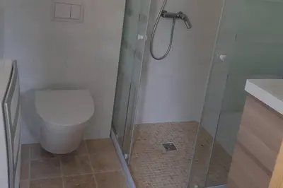 a bathroom with a toilet and a glass shower at Studio dans un cadre champêtre in Mas-Saintes-Puelles