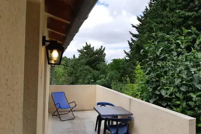a patio with a table and chairs on a fence at Studio dans un cadre champêtre in Mas-Saintes-Puelles
