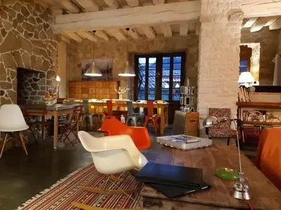 a living room with chairs and a dining room at la maison sous le château in Montségur