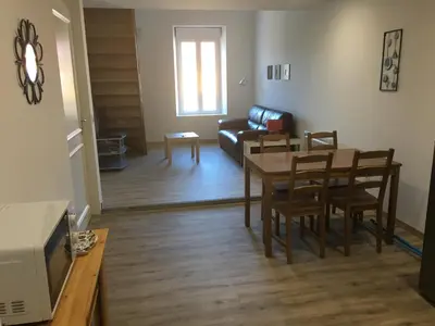 a living room with a table and chairs and a couch at La Cathare Appartement 2 chambres in Lézignan-Corbières