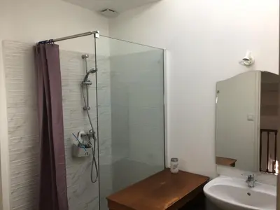 a bathroom with a glass shower and a sink at La Cathare Appartement 2 chambres in Lézignan-Corbières