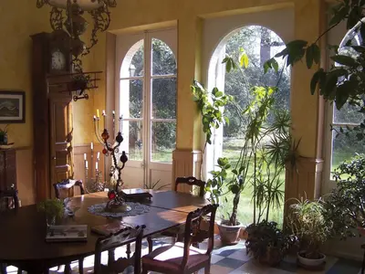 a dining room with a table and some plants at Domaine de Las Planques in Vaudreuille