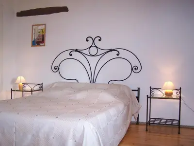 a bedroom with a large white bed with two lamps at Domaine de Las Planques in Vaudreuille