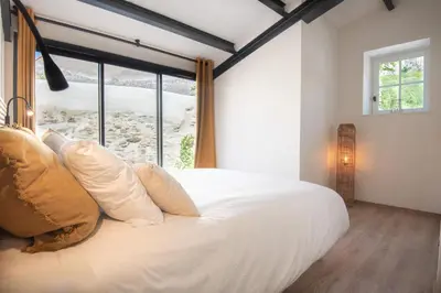 a bedroom with a large white bed with a window at Le Jardin de La Tour Pinte in Carcassonne