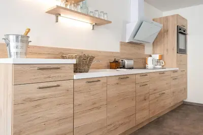 a kitchen with wooden cabinets and a sink at Le Jardin de La Tour Pinte in Carcassonne