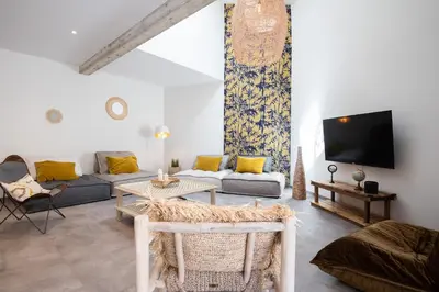 a living room with a couch and a tv at Le Jardin de La Tour Pinte in Carcassonne