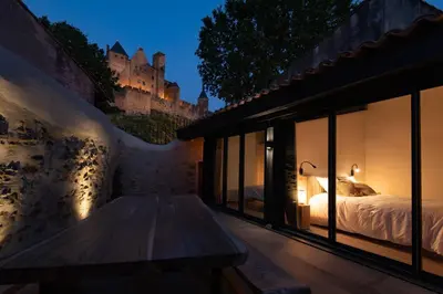 a bedroom with a bed and a view of a castle at Le Jardin de La Tour Pinte in Carcassonne