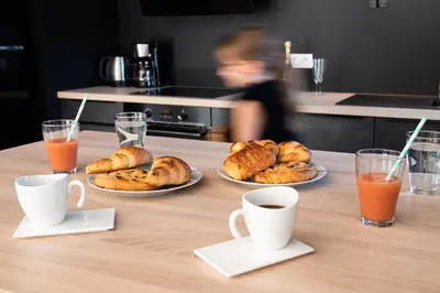 a table with plates of croissants and cups of coffee at Le Loft de La Tour Pinte in Carcassonne