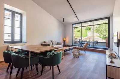 a living room with a wooden table and chairs at Le Loft de La Tour Pinte in Carcassonne