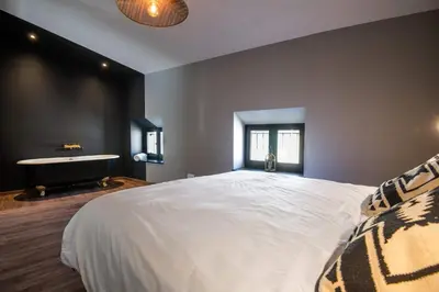 a bedroom with a large bed and a bath tub at Le Loft de La Tour Pinte in Carcassonne