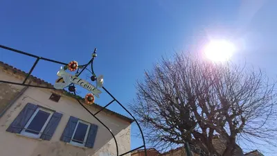 a street sign on a pole in front of a building at Infocus-Du-Sud in Soula