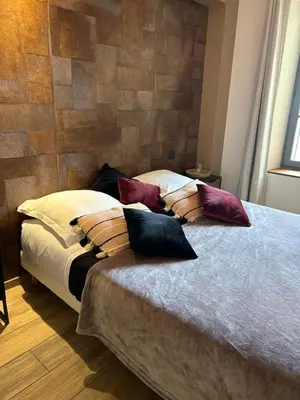 a bedroom with a large bed with pillows on it at Au pied de la Cité Médiévale, piscine, vue extraordinaire, gîte La Trivala à Carcassonne in Carcassonne