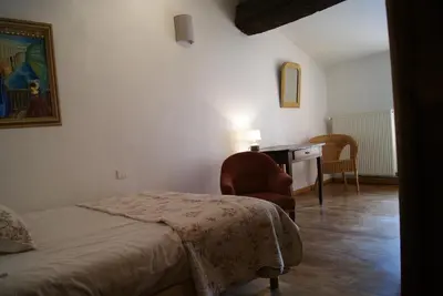 a bedroom with a bed and a desk and a chair at La piscine de tonton Jean in Caunes-Minervois