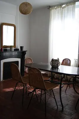 a dining room with a table and chairs and a fireplace at La piscine de tonton Jean in Caunes-Minervois