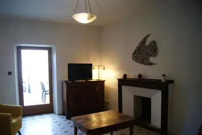 a living room with a fireplace and a tv at La piscine de tonton Jean in Caunes-Minervois