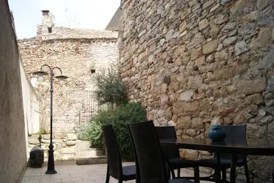 a patio with a table and chairs and a brick wall at La piscine de tonton Jean in Caunes-Minervois