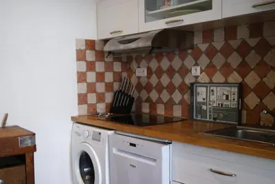 a kitchen with a washing machine and a sink at La piscine de tonton Jean in Caunes-Minervois