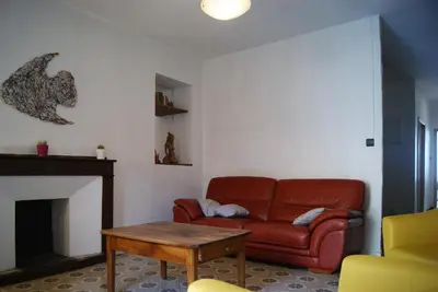 a living room with a red couch and a table at La piscine de tonton Jean in Caunes-Minervois