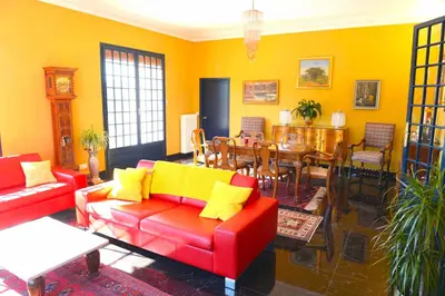 a living room with red and yellow furniture and a dining room at Chez Montiz in Montazels
