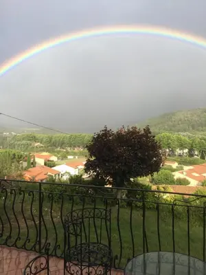 a rainbow over a balcony with chairs at Chez Montiz in Montazels