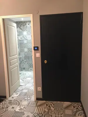 a black door in a room with a tile floor at Chez Montiz in Montazels
