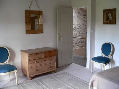 a bedroom with a bed and a dresser and two chairs at La Terrasse in Sorèze