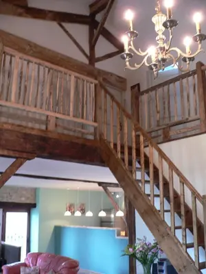a wooden staircase in a living room with a chandelier at La Terrasse in Sorèze
