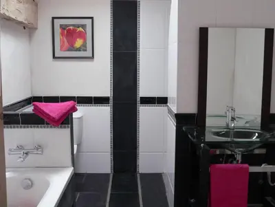 a black and white bathroom with a sink and a tub at La Terrasse in Sorèze