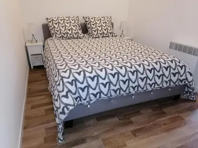 a bedroom with a bed with a black and white bedspread at Studio proche de la mer in Portel-des-Corbières
