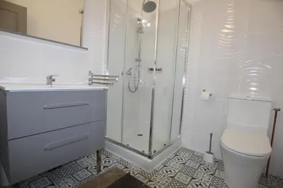 a white bathroom with a shower and a toilet at Studio proche de la mer in Portel-des-Corbières