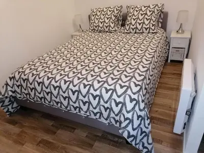 a bedroom with a bed with a black and white comforter at Studio proche de la mer in Portel-des-Corbières