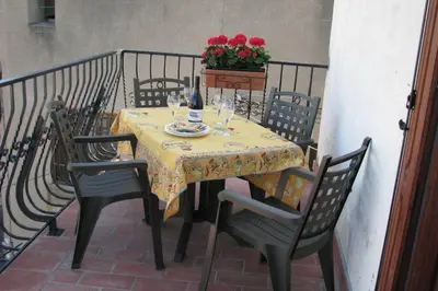 a table with chairs and a table with wine glasses at Le Sommet in Paziols