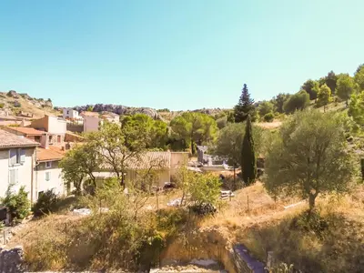 a village on a hill with houses and trees at Camin del Bosc in Roquefort-des-Corbières