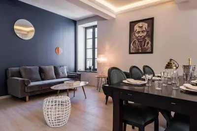 a living room with a table and a couch at La terrasse de La Tour Pinte. in Carcassonne