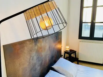 a chandelier hanging over a bed in a bedroom at Trésors de la Cathédrale, Maison de Ville sur 4 niveaux in Narbonne