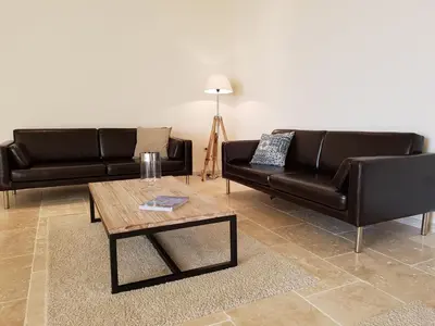 a living room with two black leather couches and a coffee table at Tranquil Stay in Villesèque in Villesèque-des-Corbières