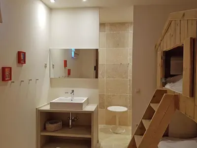 a bathroom with a sink and a staircase with a mirror at Tranquil Stay in Villesèque in Villesèque-des-Corbières