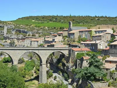 an old stone bridge over a town with houses at Tranquil Stay in Villesèque in Villesèque-des-Corbières