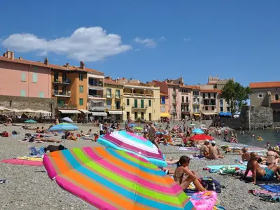 a crowd of people on a beach with umbrellas at Tranquil Stay in Villesèque in Villesèque-des-Corbières