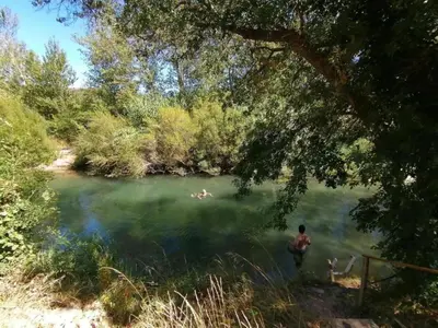 a man standing in the water in a lake at Tranquil Stay in Villesèque in Villesèque-des-Corbières