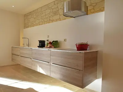 a kitchen with wooden cabinets and a sink at Cozy Escape in Villesèque in Villesèque-des-Corbières