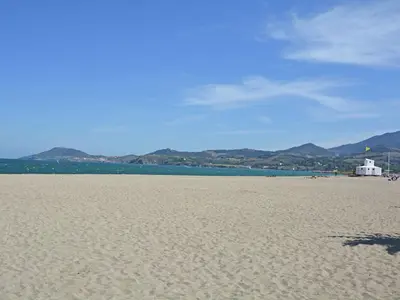 a sandy beach with a building in the distance at Cozy Escape in Villesèque in Villesèque-des-Corbières