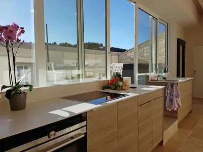 a kitchen with large windows and a counter with a sink at Blissful Stay in Mandourelle in Villesèque-des-Corbières