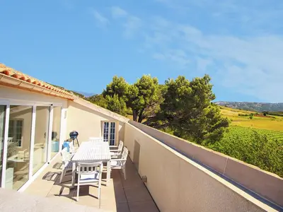 a patio with a table and chairs on a balcony at Blissful Stay in Mandourelle in Villesèque-des-Corbières