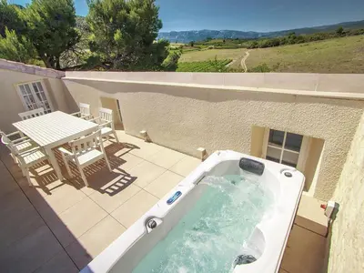 a hot tub on a patio with a table and chairs at Serene Family Escape in Villesèque-des-Corbières