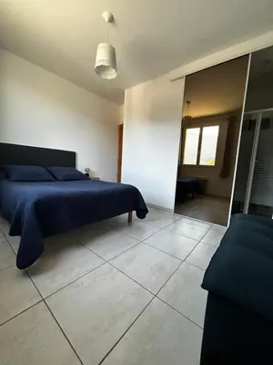 a bedroom with a blue bed and a mirror at Gîte San Jordi in Duilhac