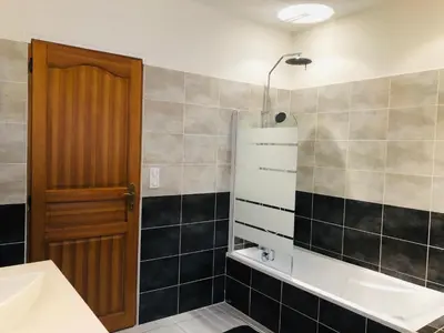 a bathroom with a tub and a sink and a mirror at Gîte San Jordi in Duilhac