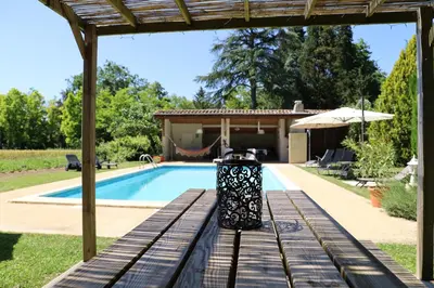 a pool in a backyard with a trash can next to it at Domaine de Pouroutounat in Mirepoix